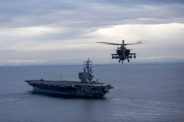 A U.S. Army AH-64 Apache assigned to 1-229th Attack Battalion “Tigarsharks”, 16th Combat Aviation Brigade, 7th Infantry Division prepares to perform a deck landing on the USS Ronald Reagan (CVN 76) during deck landing qualifications while...