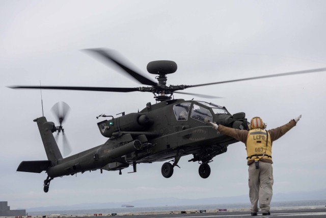 A U.S. Army AH-64 Apache assigned to 1-229th Attack Battalion “Tigersharks”, 16th Combat Aviation Brigade, 7th Infantry Division performs a deck landing on the USS Ronald Reagan (CVN 76) during deck landing qualifications while underway in the...
