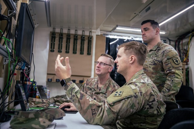 Sgt. 1st Class Demetrius Milczakowskyj (center), a senior fire control non-commissioned officer, assigned to Headquarters and Headquarters Battalion, 4th Infantry Division Artillery, 4th Infantry Division, briefs Lt. Col. David Graves (left),...