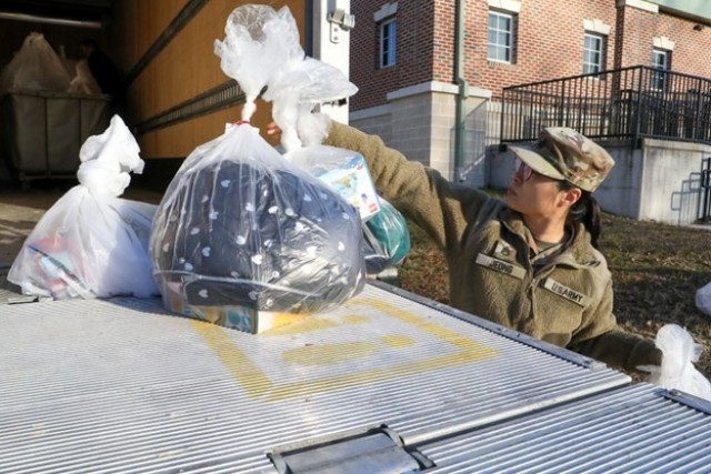 U.S. Army Soldier Staff Sgt. Suzy Jeong from the 7th Signal Command (Theater) loads bags of donated gifts onto a truck on Fort Meade, MD, on December 9, 2025.