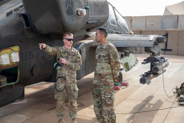 U.S. Army Spc. Christopher Allen, an AH-64 maintainer assigned to Alpha Troop, 6th Squadron, 17th Cavalry Regiment, Task Force Nighthawk briefs Mr. Nihar Patel, chief technology officer for 4th Infantry Division, on the mechanics of the AH-64D...