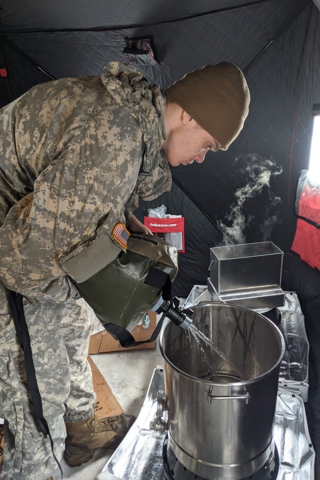Soldiers and Marines test the new Expeditionary Field Feeding Equipment System while training in the Arctic. The EFFES is a lightweight, collapsible kitchen in a box that has a stove, seen in the center, that cooks faster with less fuel...