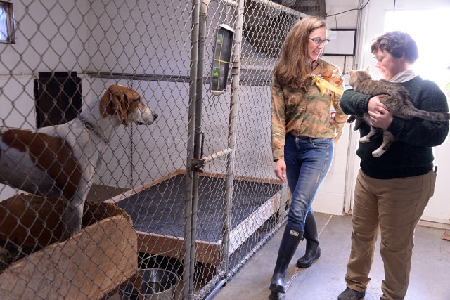 Fort Leavenworth Hunt member Lt. Col. Jessamyn Jempson, Combined Arms Doctrine Directorate, walks with “kennelman” Ruth Hensleigh as she carries resident kennel cat Pete through the kennels during the FLH Hounds for the Holidays event Dec. 7,...