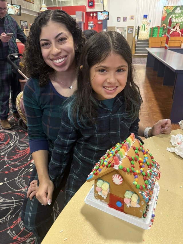 Gingerbread showdown contestants show off their gingerbread house as Fort McCoy community members participate in the 2025 Breakfast with Santa, Gingerbread House Showdown event Dec. 5, 2025, at Fort McCoy, Wis. Dozens of Fort McCoy community...