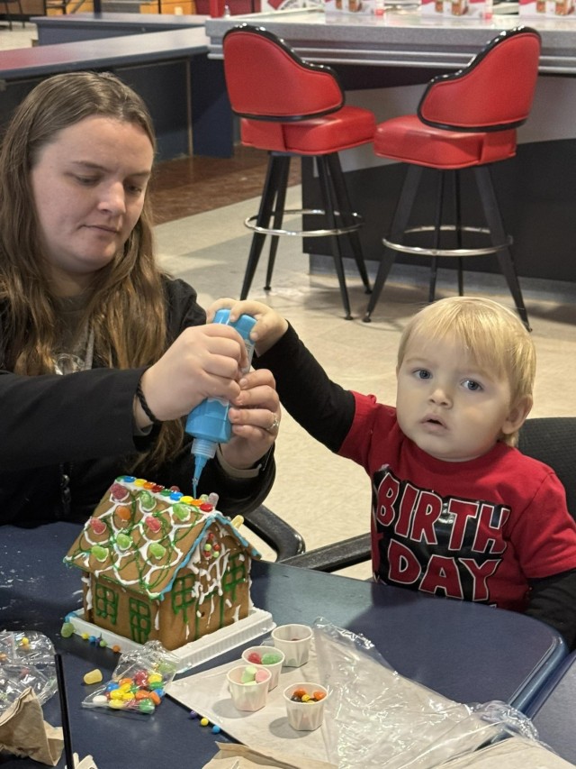 Gingerbread showdown contestants show off their gingerbread house as Fort McCoy community members participate in the 2025 Breakfast with Santa, Gingerbread House Showdown event Dec. 5, 2025, at Fort McCoy, Wis. Dozens of Fort McCoy community...