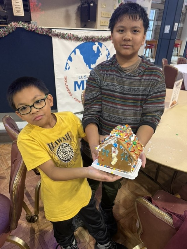 Gingerbread showdown contestants show off their gingerbread house as Fort McCoy community members participate in the 2025 Breakfast with Santa, Gingerbread House Showdown event Dec. 5, 2025, at Fort McCoy, Wis. Dozens of Fort McCoy community...