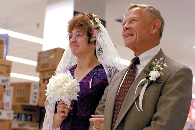 Jack Walker prepares to walk Glennie Morris, commissary manager, down the aisle during her wedding Sept. 17, 2001. Morris married Joseph Klubeck over her lunch hour at the Fort Leavenworth Commissary at Fort Leavenworth, Kansas. Photo by Prudence...