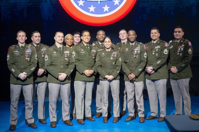 A group of Soldiers pose for a photo during ceremonies honoring the top Army recruiters of fiscal year 2025.