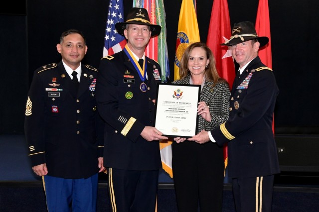Brig. Gen. Jonathan C. Byrom and his wife, Marsha, take a photo with his certificate of retirement with USACRC Command Sgt. Maj. Jean Pierre Alcedo (left) and retired Maj. Gen. John Richardson (right) during Byrom's retirement ceremony held...