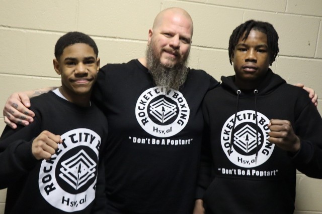 Retired Chief Warrant Officer 4 Steve Badgley, of the Corps of Engineers, helps coach Gabriel Johnson, 11, and Miguel “Floyd” Spells, 14, at Rocket City Boxing. Both will compete in the USA Boxing National Silver Gloves Tournament, Feb. 25-28...
