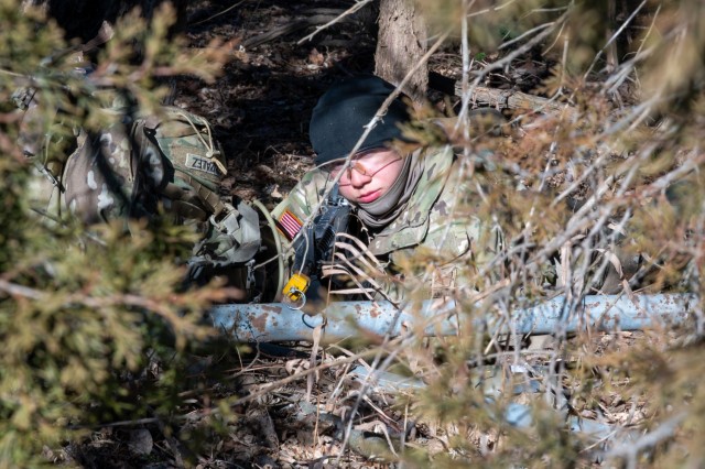 Pvt. Valerie Gonzalez, a Soldier in training with Company C, 35th Engineer Battalion, maintains a concealed position inside vegetation during a field training exercise Jan. 21 at Fort Leonard Wood.