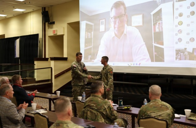Maj. Gen. Clair A. Gill, Aviation Center of Excellence commanding general, congratulates 1st Lt. Cooper Gentry, a student aviator who recently completed Ranger School while in a flight school hold status, as the Hon. Michael A. Obadal, Under...
