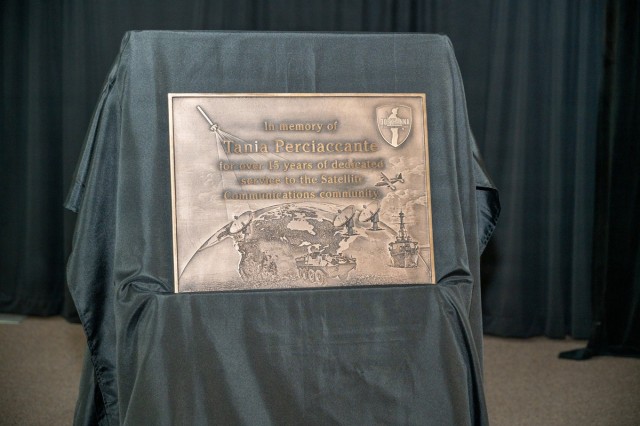 A memorial plaque to Tania Perciaccante sits on an easel covered in drapes.