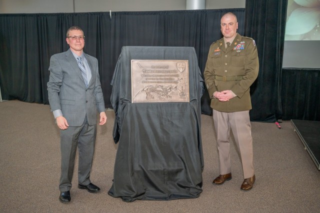 Tobyhanna Army Depot Chief of the Wideband Control Test Division Jeremy Buratt (left) and Tobyhanna Army Depot Commander Col. Benjamin L. Kilgore (right) stand on either side of a memorial plaque.