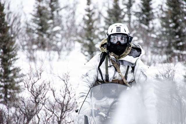 Green Beret drives snowmobile toward reconnaissance site