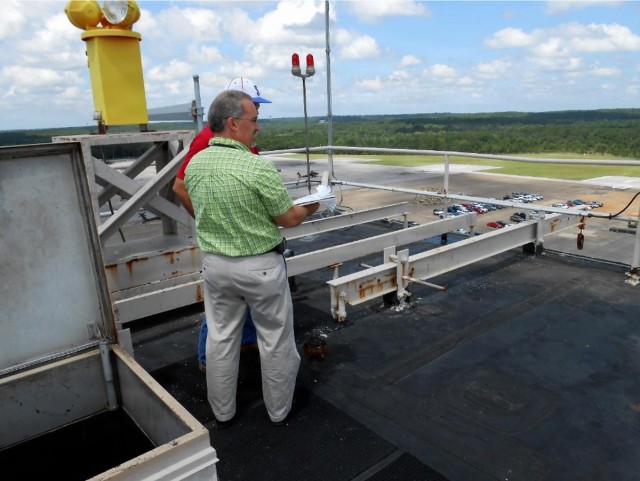 Wayne Wilkinson, Air Traffic Control Engineering team lead, is documenting the legacy radio antenna configuration while conducting a site survey of the air traffic control tower roof at Hanchey Army Heliport on Fort Rucker, Ala.