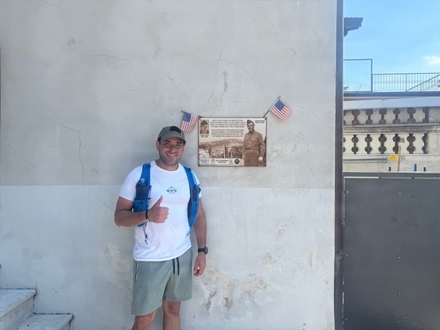 U.S. Army Capt. Javier Pino, with U.S. Army Veterinary Readiness Activity, Rheinland-Pfalz, poses beside a plaque honoring Col. William O. Darby.